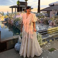 Okky Lukman memilih tampil memukau dengan dress panjang berwarna krem. Dress tersebut dipenuhi detail ruffle yang menjalar dari bagian bahu sampai bawah kakinya. Foto: Instagram