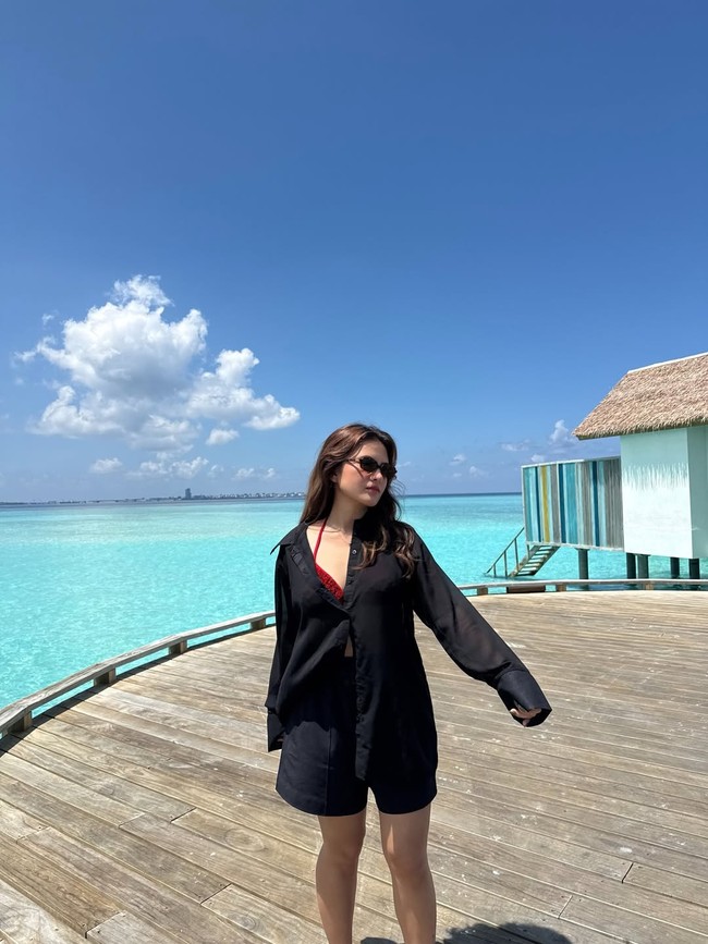 Marsha tampak memakai bikini merah di balik shirt dress. Kacamata hitam hadir sebagai pelengkap busana sekaligus melindungi mata dari teriknya sinar matahari. Foto: Instagram/@marshaaruan