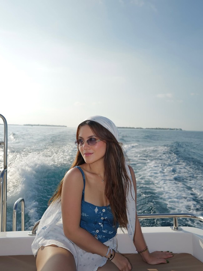 Pose di speed boat, wanita 29 tahun ini tampil chic dengan camisole indigo dipadu skort putih. Scarf sebagai headpiece mempermanis penampilannya. Foto: Instagram/@marshaaruan