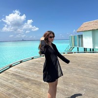 Berjemur di bawah sinar matahari dengan latar langit dan laut biru, Marsha mengenakan busana hitam yang kontras. Shirt dress dipadu celana pendek menampilkan gaya casual yang tetap stylish. Foto: Instagram/@marshaaruan