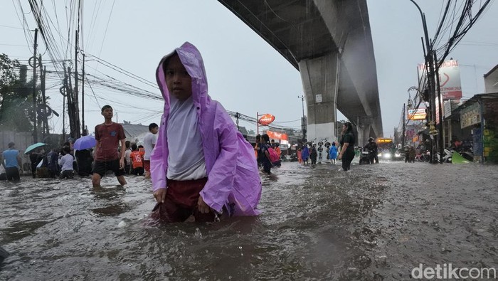 Para pengendara menerobos banjir setinggi hampir satu meter di perempatan Cipulir, Jakarta Selatan, Senin (4/5/2026).