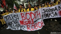Massa membawa poster tuntutan saat aksi Hardiknas. 