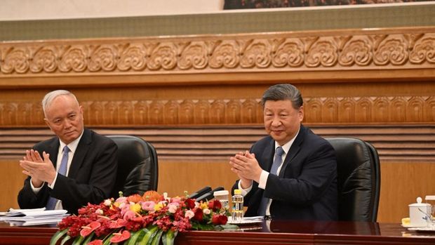 Presiden China Xi Jinping (kanan) dan Cai Qi, pejabat tinggi Partai Komunis, bertepuk tangan saat pertemuan dengan sekelompok eksekutif asing di Balai Besar Rakyat di Beijing pada 28 Maret 2025. (Photo by ADEK BERRY / AFP/File Foto)