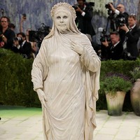 Heidi Klum tampil bak patung marmer saat melenggang di karpet merah Met Gala 2026. Penampilannya terinspirasi dari karya pematung Italia Raffaele Monti, yakni patung Veiled Vestal. Patung tersebut direplikasi tim Heidi menggunakan bahan lateks dan busa untuk memberikan tampilan seperti batu. Foto: Getty Images/Mike Coppola