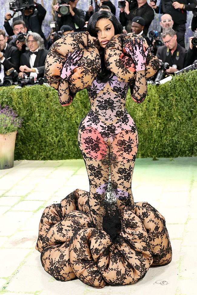 Cardi B tampil ekstra di karpet merah Met Gala 2026 dengan mengenakan gaun lace ruffle kustom rancangan Marc Jacobs. Gaun dilapisi di atas bodysuit color-block dipadukan dengan sepatu boots platform setinggi 9,5 inci atau sekitar 24 cm. Penampilannya ini terinspirasi dari karya seniman Jerman Hans Bellmer, serta koleksi runway Marc Jacobs Fall 2025 yang menonjolkan siluet dengan volume berlebihan. Foto: Getty Images/Mike Coppola
