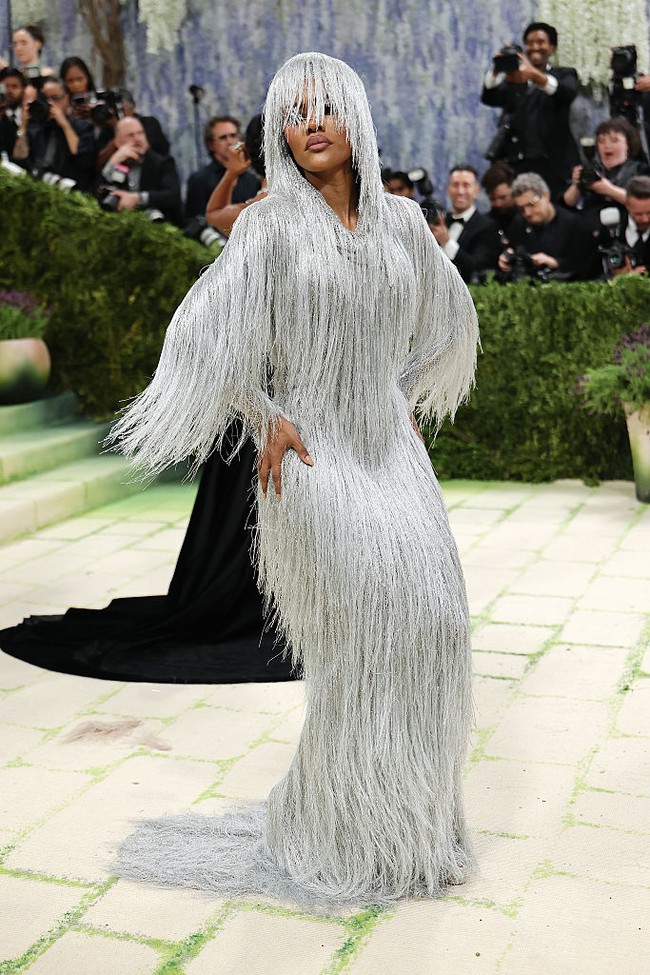 Teyana Taylor yang merupakan bagian dari komite tuan rumah Met Gala 2026, mengenakan gaun perak berumbai rancangan Tom Ford lengkap dengan hiasan kepala senada yang menjuntai menutupi setengah wajahnya. “Gaunnya terlihat seperti meleleh saat saya bergerak. Saya suka menganggapnya sebagai ‘hantu dari sebuah tubuh,’ yang muncul dan menghilang, muncul dan menghilang seiring saya bergerak,” kata aktris One Battle After Another. Foto: Getty Images/Mike Coppola