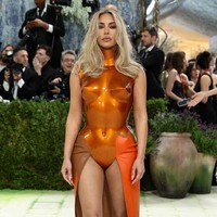 Kim Kardashian mengusung estetika pop art lewat breastplate fiberglass oranye karya Allen Jones yang berasal dari cetakan arsip tahun 1960-an; diproduksi ulang dengan teknik modern, tampilan ini terasa provokatif, industrial, dan konseptual, sekaligus menegaskan hubungan erat antara seni rupa klasik dan fashion kontemporer. Foto: Getty Images