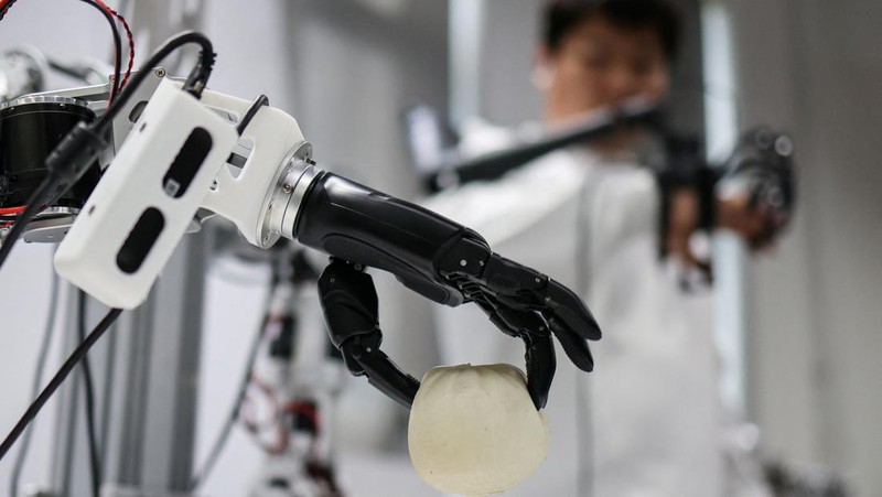 An ensemble of humanoid robots produced by Linkerbot is set up with musical instruments as a woman holding a wipe walks nearby, at the company’s office in Beijing, China, April 27, 2026. REUTERS/Maxim Shemetov