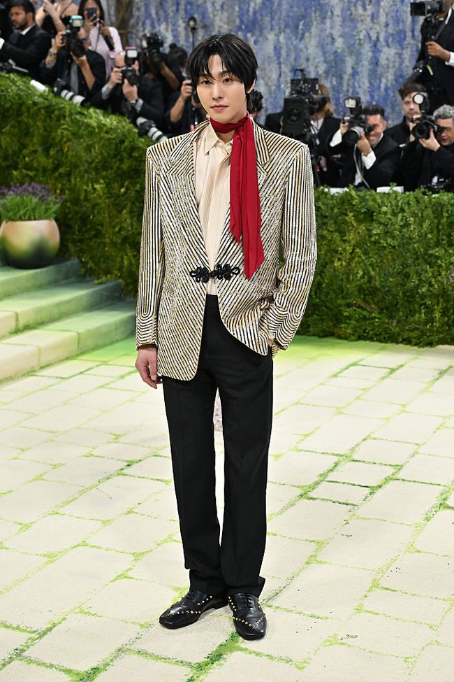 Di antara deretan wanita cantik Korea yang hadir di MET Gala 2026, ada aktor Ahn Hyo Seop yang membuat penampilan perdananya. Pengisi suara KPop Demon Hunters itu tampil dengan gaya flamboyan memakai setelan jas hitam berhias payet emas dari Valentino. Ia melengkapi penampilannya dengan syal warna merah. Foto: Getty Images