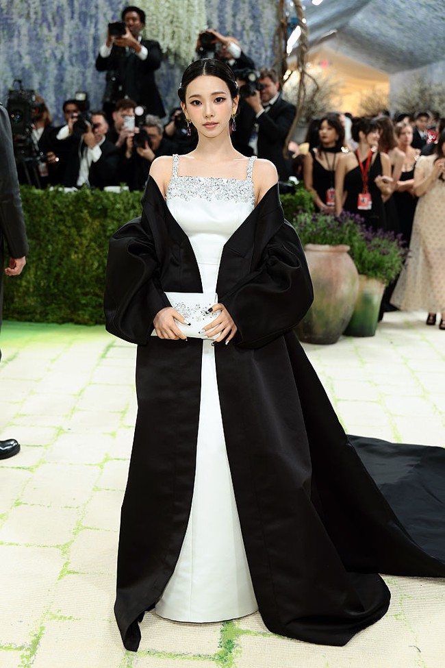 Karina aespa membuktikan reputasinya dengan visual unreal bak AI. Untuk debutnya di MET Gala 2026, pelantun Armageddon itu mengenakan gaun sutra putih dari Prada yang berkilauan.  Dilengkapi jubah hitam yang menjuntai serupa hanbok alias baju tradisional Korea. Foto: Getty Images