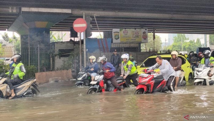 Kendaraan roda dua menerobos banjir di simpang lampu merah Puri Kembangan, Kembangan Selatan, Jakarta Barat, Selasa (4/5/2026) pagi. ANTARA/Risky Syukur
