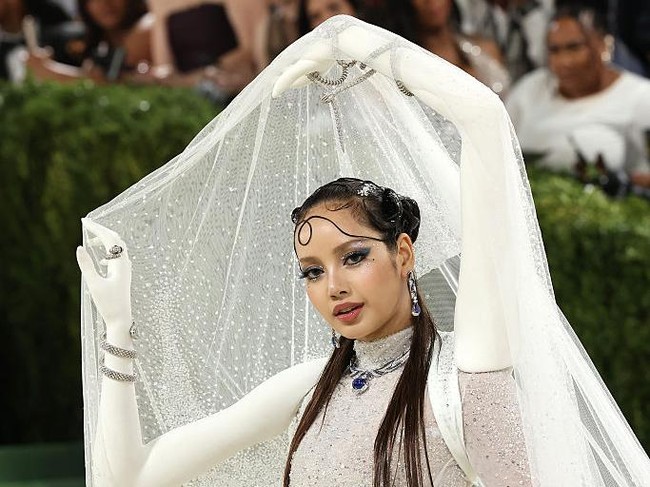 Semua detail dari penampilan Lisa terasa playful sekaligus maksimal. Eyeshadow biru yang sedang tren dipadukan dengan taburan gems di area mata, menciptakan efek berkilau yang mencuri fokus. Rambutnya ditata sleek dalam half-updo dengan sentuhan sculptural di bagian depan. Tak berhenti di situ, kuku hingga tangan dihiasi rhinestones perak dan aksen biru senada. Foto: Dok. Getty Images