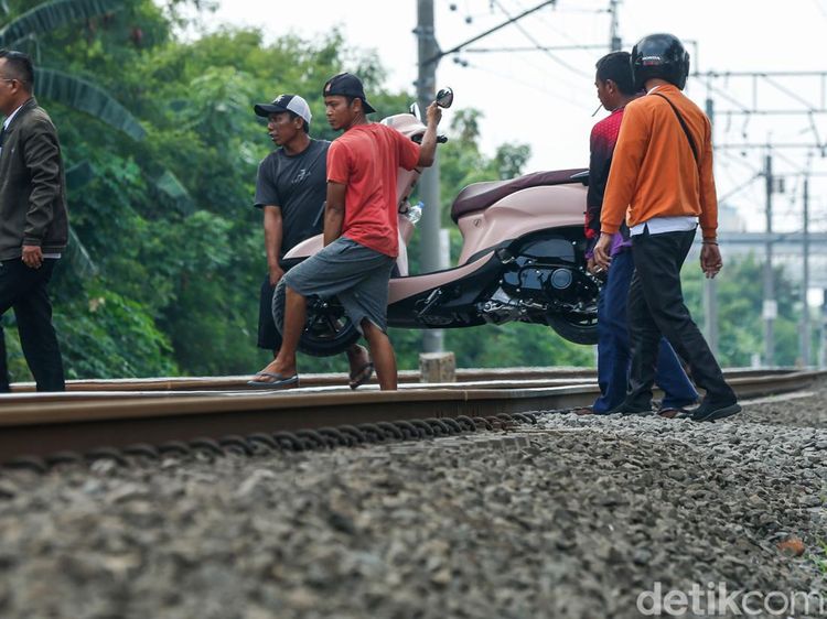Nekat! Warga Buka Jasa Gotong Motor di Perlintasan KA Tanpa Palang