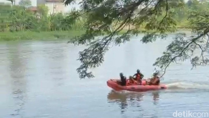 Petugas BPBD mencari orang yang hanyut di Sungai Brantas