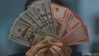 Karyawan menunjukkan uang pecahan rupiah dan dolar Amerika Serikat (AS) di gerai penukaran mata uang asing Ayu Masagung, Jakarta, Selasa (5/5/2026).