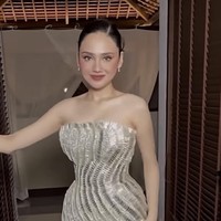 Daya tarik utama terletak pada permainan embellishment tiga dimensi berupa manik-manik perak dan payet yang disusun menyerupai gelombang. Efek kilau dari material silver bead dan sequin semakin mempertegas kesan mewah. Saat terkena cahaya, setiap detail memantulkan sinar secara berbeda, menghasilkan tampilan shimmer yang berubah-ubah mengikuti pergerakan tubuh. Inilah yang membuat gaun ini terasa ‘hidup’, seolah menari bersama pemakainya. Foto: Instagram/@mryogiepratama
