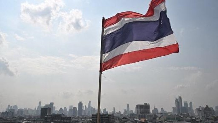 The Thai flag is seen with the city skyline the day after the general election, in Bangkok on February 9, 2026. (Photo by Lillian SUWANRUMPHA / AFP)