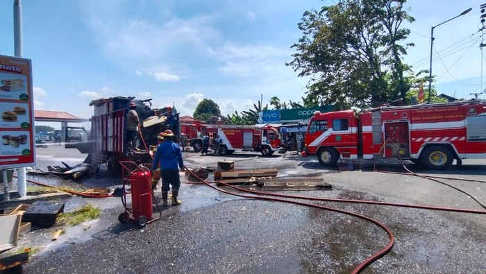 Petugas melakukan pembasahan truk yang terbakar di di depan SPBU Albatros, Jalan Raya Juanda, Kabupaten Sidoarjo