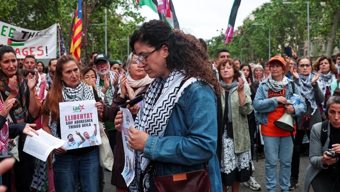 Saif Abu Keshek's wife, Sally Issa, holds a banner reading 