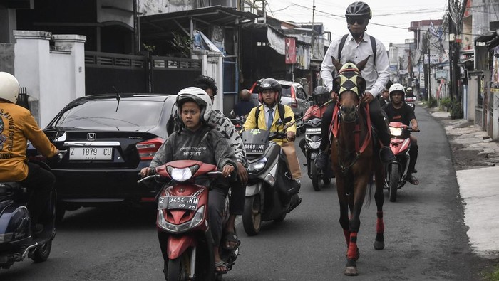 Aparatur Sipil Negara (ASN) Pemerintah Kota Tasikmalaya Mohammad Arif Syamsani menunggang kuda saat berangkat kerja pada program hari bebas kendaraan bermotor (car free day) di Kota Tasikmalaya, Jawa Barat, Rabu (6/5/2026). Pemerintah Kota Tasikmalaya membatasi penggunaan kendaraan dinas hingga 50 persen serta mendorong ASN beralih ke transportasi publik dan efisiensi perjalanan dinas untuk menekan penggunaan BBM. ANTARA FOTO/Adeng Bustomi/bar