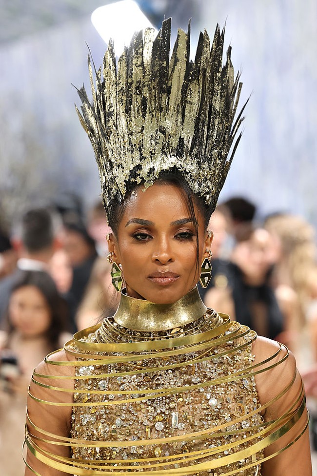 Terinspirasi dari sosok ‘Nefertiti,’ Ciara menghadirkan tampilan yang artistik. Rambutnya ditata sleek dengan lapisan glitter dan gold foil, menciptakan efek yang hampir menyerupai karya seni instalasi. Foto: Getty Images/Jamie McCarthy