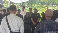 Vicky Zainal, kakak Bunga memakai pasmina biru dongker menangis melihat jenazah ayah dimasukan ke dalam liang lahad. Foto: Muhammad Ahsan Nurrijal/detikcom