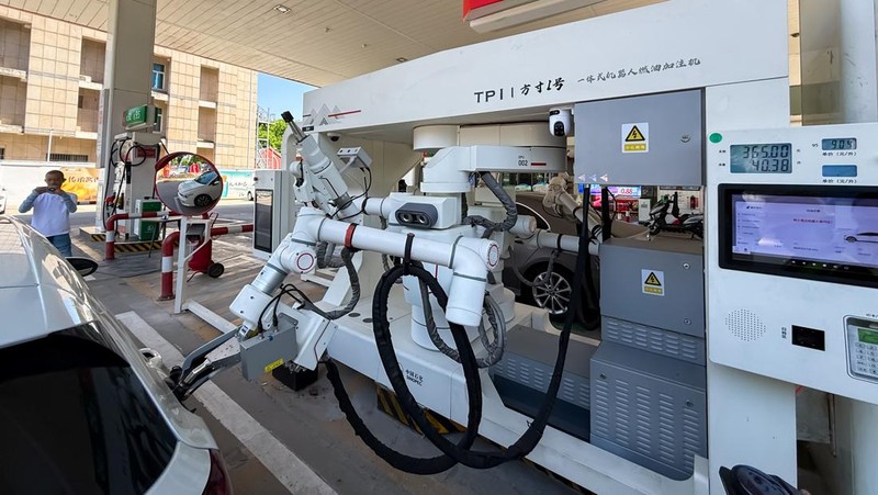 ZHENGZHOU, CHINA - MAY 05: An intelligent refueling robot works at a Sinopec gas station on May 5, 2026 in Zhengzhou, Henan Province of China. The refueling robot integrates AI vision recognition and high-precision robotic arm to automatically identify vehicle models, open fuel tank caps and perform precise refueling without requiring the drivers to stepping out of cars. The autonomous system can complete the entire refueling process in only 120 seconds. (Photo by VCG/VCG via Getty Images)