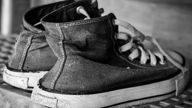 Ilustrasi sepatu A pair of dirty canvas shoes on a shelf