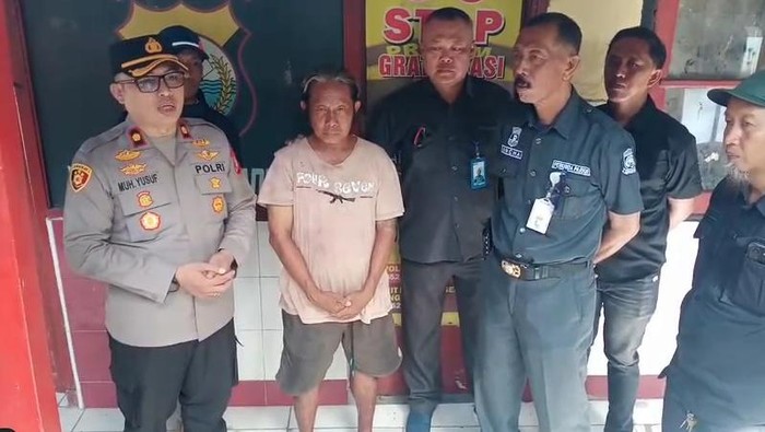 Jukir bernama Herman (tengah) dipulangkan setelah sempat diamankan polisi karena mematok tarif Rp 20 ribu kepada pengendara mobil di Makassar.