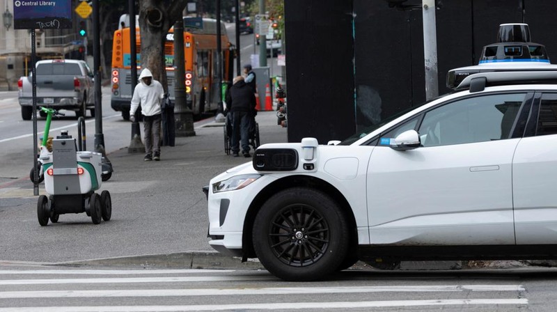 An autonomous food delivery robot passes a pod of electric scooters in downtown Los Angeles, California, U.S., May 1, 2026.  REUTERS/Mike Blake