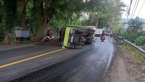 Truk bermuatan pasir terguling di jalur Amlapura-Denpasar akibat as patah hingga menyebabkan kemacetan, Rabu (6/5/2026). (Dok. Satlantas Polres Karangasem)