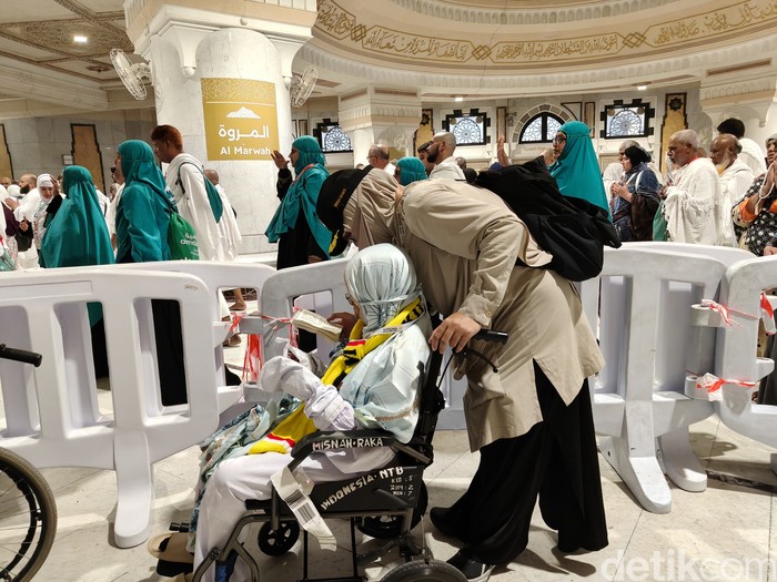 Petugas Linjam PPIH Arab Saudi, Deka Ulfa Wiwik Irjayanti, membantu jemaah lansia melakukan sai menggunakan kursi roda.