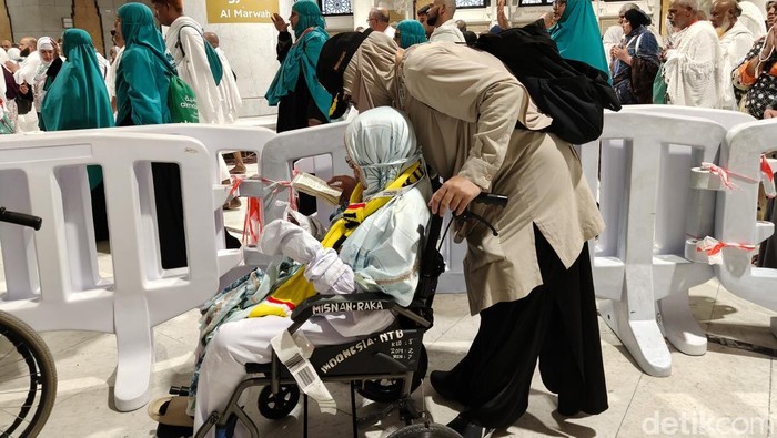 Petugas Linjam PPIH Arab Saudi, Deka Ulfa Wiwik Irjayanti, membantu jemaah lansia melakukan sai menggunakan kursi roda.