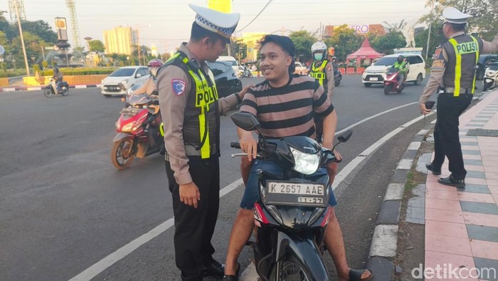 Kasat Lantas AKP Yudhi Anugrah Putra melakukan pendekatan humanis kepada pengendara di Bunderan TPI Sidoarjo yg tidak memakai helm