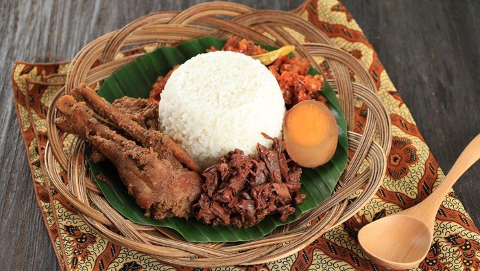 Nasi Gudeg Krecek is rice and gudeg, which is made from processed young jackfruit, coconut milk, spices, tofu, eggs and chicken. Yogyakarta specialties. Indonesian food. Served with banana leaves.