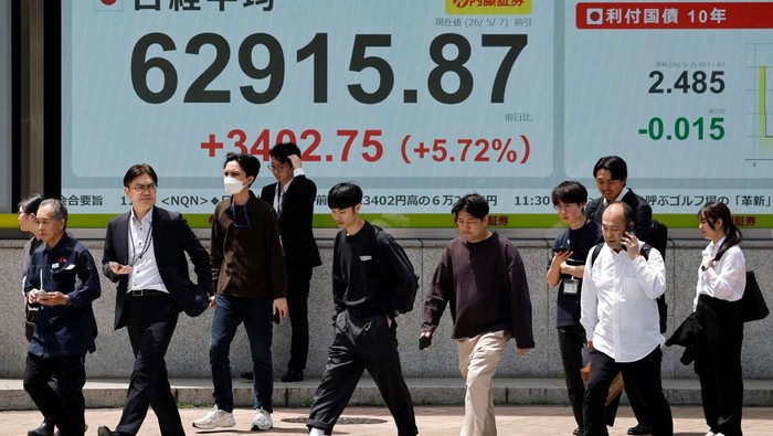 Pasar Jepang Bergairah, Nikkei Tembus Rekor Pedestrians walk past a stock quotation board showing the Nikkei share average outside a brokerage in Tokyo, Japan, May 7, 2026. REUTERS/Kim Kyung-Hoon