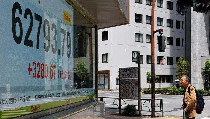 Pasar Jepang Bergairah, Nikkei Tembus Rekor Pedestrians walk past a stock quotation board showing the Nikkei share average outside a brokerage in Tokyo, Japan, May 7, 2026. REUTERS/Kim Kyung-Hoon