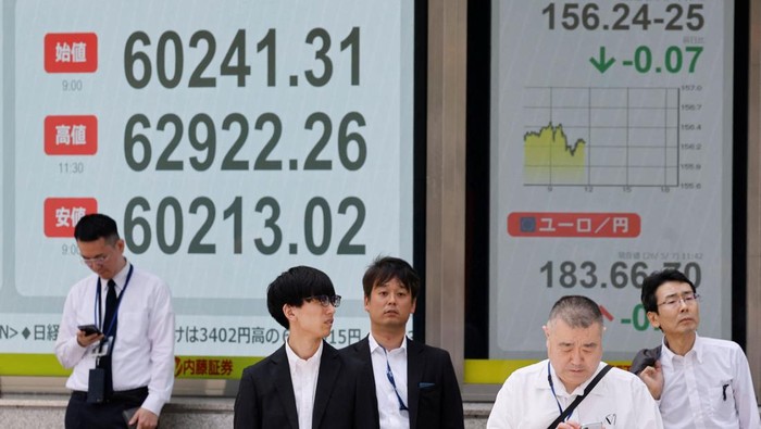 Pedestrians walk past a stock quotation board showing the Nikkei share average outside a brokerage in Tokyo, Japan, May 7, 2026. REUTERS/Kim Kyung-Hoon