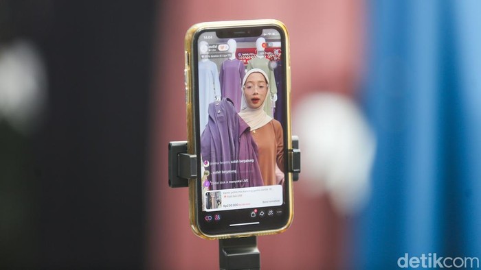 Pedagang Online Keluhkan Biaya Ongkir Baru Marketplace Pekerja melakukan siaran langsung penjualan pakaian melalui aplikasi belanja e-commerce di kawasan Tanah Abang, Jakarta, Kamis (7/5/2026).