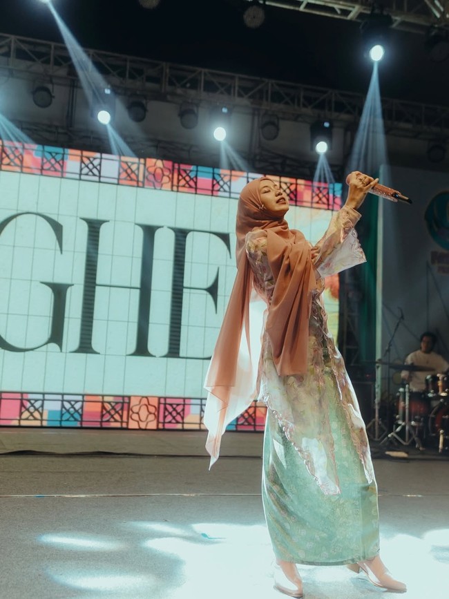 Padu padan hijab ini dengan kebaya floral transparan dan rok satin hijau mint memancarkan aura lembut sekaligus anggun di bawah sorotan lampu panggung yang megah. Foto: Dok. Instagram @gheaindrawari