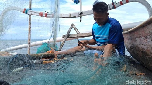 Ilustrasi - Seorang nelayan memperbaiki jaring ikan di pesisir Bintaro, Ampenan, Kota Mataram, NTB, beberapa waktu lalu. (Foto: Nathea Citra/detikBali)