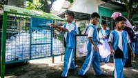 Siswa memasukan sampah kedalam kotak sampah pilah saat kegiatan pengelolaan bank sampah di SD Negeri Kedunglumbu, Pasar Kliwon, Solo, Jawa Tengah. Foto: ANTARA FOTO/Mohammad Ayudha
