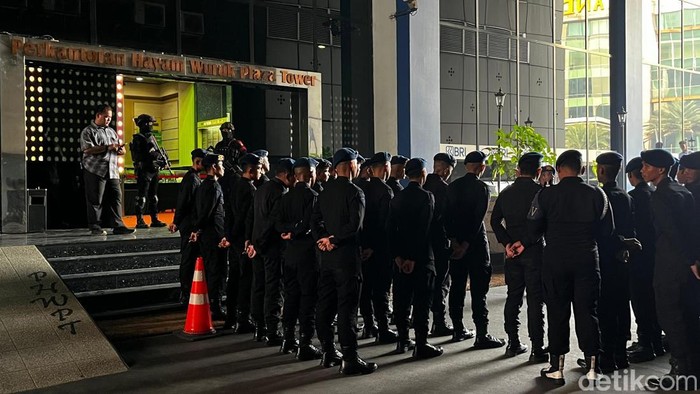 Sejumlah personel Brimob menjaga perkantoran di Hayam Wuruk Jakpus terkait penggerebekan yang dilakukan Bareskrim terkait aktivitas judi online (judol). (Rumondang/detikcom)
