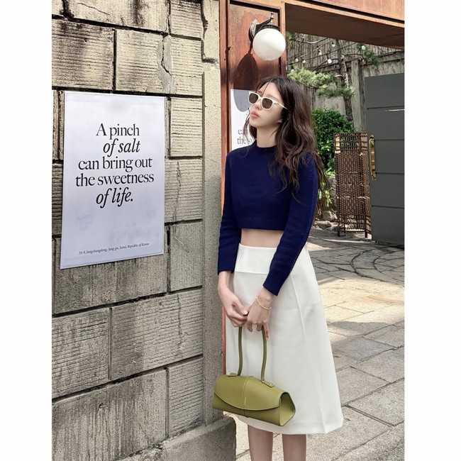 Bintang drama Korea The Penthouse itu tampil stylish memadukan crop top berwarna biru, midi skirt putih, lengkap dengan kacamata hitam. Foto: dok. Instagram @e.jiah