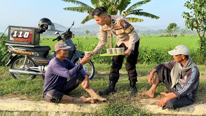 Polisi saat melakukan sosialisasi 110 melalui wedangan keliling.