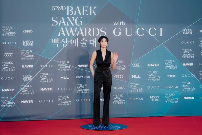 Alih-alih memakai gaun, Seol In Ah memilih tampilan androgini dengan setelan vest, celana panjang berpotongan flare, dan heels serba hitam. Foto: dok. Instagram @_seorina