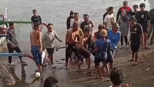 Warga mengevakuasi SB (48), pria yang yang ikut terseret arus saat hendak selamatkan dua anak di Pantai Muara Perancak, Jembrana, Minggu (10/5/2026). (Istimewa)