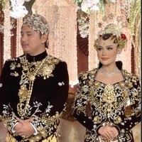 Sementara itu, mempelai pria mengenakan beskap velvet senada dengan detail bordir emas dan perak di bagian dada serta lengan. Ornamen bordir bernuansa floral dan klasik Jawa membuat tampilannya terlihat berwibawa. Beskap dipadukan dengan kain batik sogan tradisional bermotif besar dalam warna cokelat-krem khas Jawa. Foto: Instagram/@ivan_gunawan