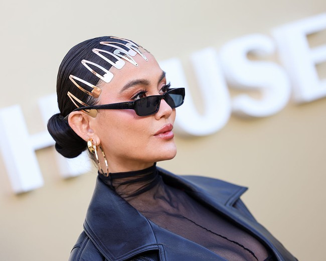 Turut melengkapi gaya Pelantun ‘Coke Bottle’ ini, aksesori bernuansa emas yang sarat statement, mulai dari bangles yang chunky dan anting hoop berukuran besar. Tidak ketinggalan tas bulu kacamata hitam untuk tampilan yang lebih urban. (Foto: Chad Salvador/WWD via Getty Images)