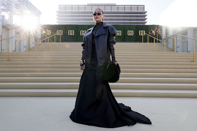 Look andalan Agnez terdiri dari oversized leather jacket yang membungkus atasan menerawang dan bra top. Bawahan berupa rok megar berstruktur yang arsitektural menciptakan kesan dramatis. (Foto: Rodin Eckenroth/Getty Images for Gold House)